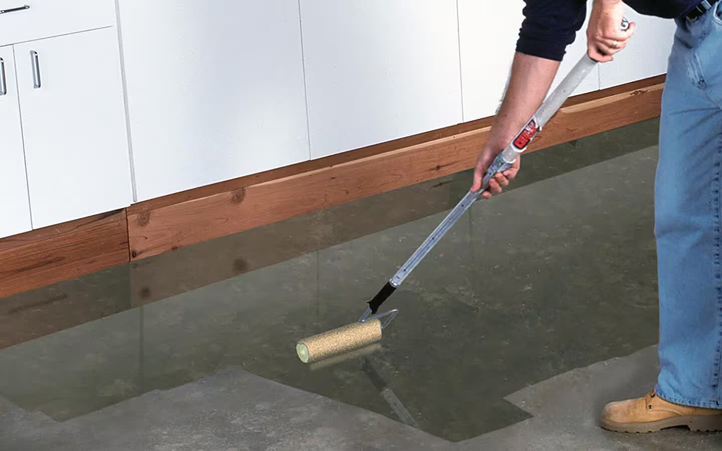 Contractor rolling a clear sealer onto a stained concrete driveway in Lake City, Florida